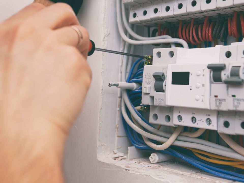 Electrician installing digital circuit breaker in residential electrical panel