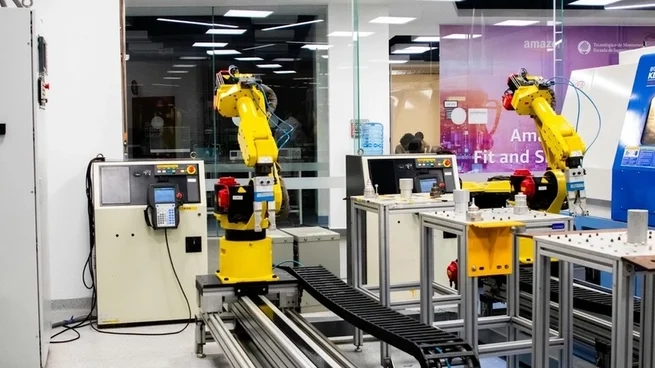 A modern manufacturing floor featuring industrial automation systems with robotic arms, conveyor belts, and digital control terminals for high-precision assembly.